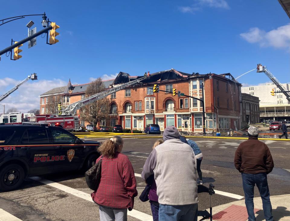 A crowd of onlookers gather as crews from the Newark Fire Department battle a blaze Saturday in the attic of the Avalon Apartments, 86 W. Main St., at North Fifth Street, in downtown Newark.