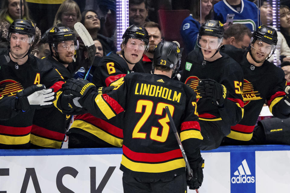 Vancouver Canucks' Elias Lindholm (23) is congratulated for his goal against the Detroit Red Wings during the first period of an NHL hockey game Thursday, Feb. 15, 2024, in Vancouver, British Columbia. (Ethan Cairns/The Canadian Press via AP)