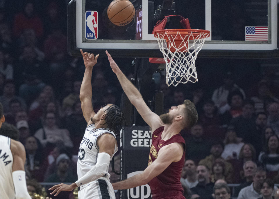 San Antonio Spurs' Tre Jones (33) shoots over Cleveland Cavaliers' Dean Wade (32) during the first half of an NBA basketball game in Cleveland, Sunday, Jan. 7, 2024. (AP Photo/Phil Long)