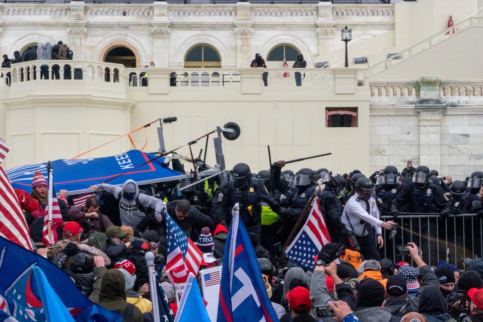 <strong>Washington, D.C., Jan. 6, 2021.</strong> "When I arrived, clashes with the police had already begun. The number of police was very limited, but they seemed to be holding the rioters back. As I looked back on the Mall, I could see tens of thousands of people approaching. Nonetheless, a few additional police arrived. From my vantage point on a wall, I observed a well-organized group of men on megaphones exhorting 'good, strong men' forward to 'take back our house.' The crowd obliged, clambering over makeshift ladders to pressure the police back. A large crowd moved towards the East side of the Capitol, and I followed them. They pushed through police lines and surrounded the Capitol Police below, who retreated under a cloud of tear gas. The triumphant crowd began battering at the doors and windows. A man stopped by a broken flagstone and made a big show of proclaiming how 'dangerous' it would be if someone tripped and twisted their ankle. 'Typical Washington swamp,' he sniffed."<span class="copyright">Peter van Agtmael—Magnum Photos for TIME</span>