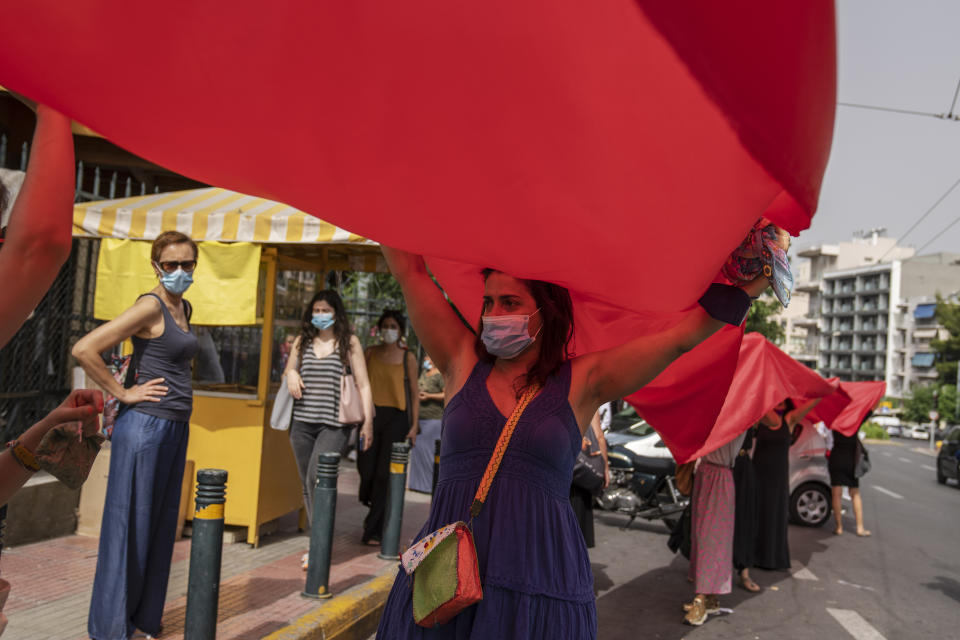 Protesters take part in a rally against domestic violence outside a court house where helicopter pilot Babis Anagnostopoulos is giving evidence after being charged with the murder of his British-Greek wife, in Athens, Tuesday, June 22, 2021. Anagnostopoulos was charged last Friday with the murder of Caroline Crouch, 20, whose death he had initially claimed was caused by burglars during a brutal invasion of their home on the outskirts of Athens. (AP Photo/Petros Giannakouris)