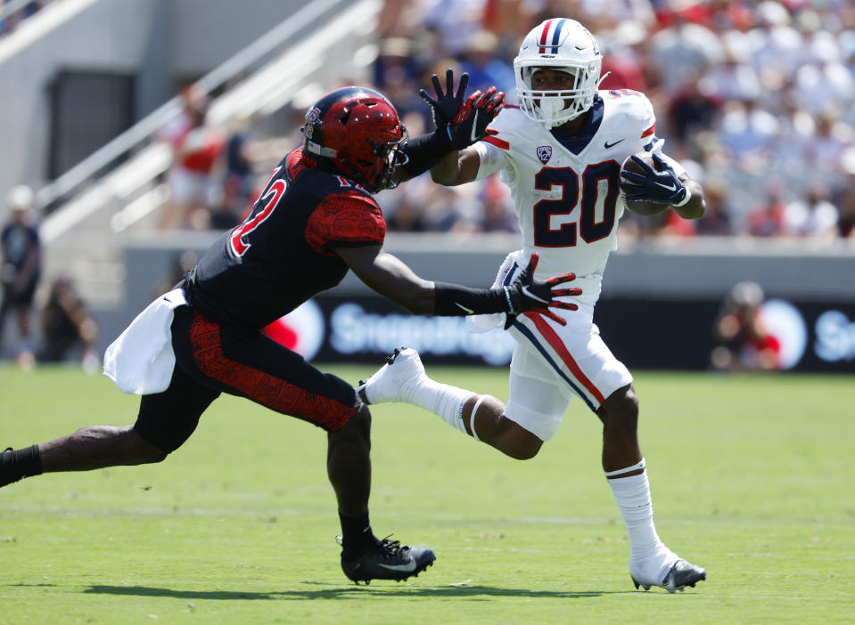 Arizona's Rayshon Luke (20) runs the ball as San Diego State's Dallas Branch defends in the second quarter of an NCAA college football game Saturday, Sept. 3, 2022, in San Diego. (K.C. Alfred/The San Diego Union-Tribune via AP)