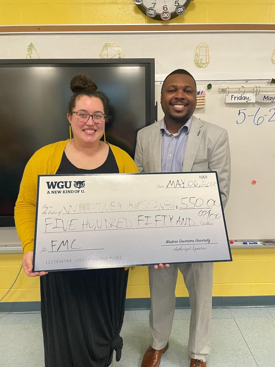 Whitney Kessinger, left, a first-grade teacher at Chester East Lincoln Elementary School, received a $550 grant from Dr. Terrance Hopson, Regional Director of Western Governors University.