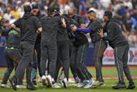 Tampa Bay Rays players mob Jonny DeLuca after his game-winning hit off New York Mets relief pitcher Jake Diekman during the 10th inning of a baseball game Sunday, May 5, 2024, in St. Petersburg, Fla. (AP Photo/Chris O'Meara)