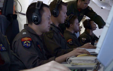 U.S. Navy flight officer Zachary Collver, mission commander at the Boeing P-8A Poseidon aircraft, works alongside other officers during the search for the ARA San Juan submarine missing at sea as they fly over the South Atlantic Ocean, Argentina November 22, 2017. Picture taken November 22, 2017. REUTERS/Magali Cervantes