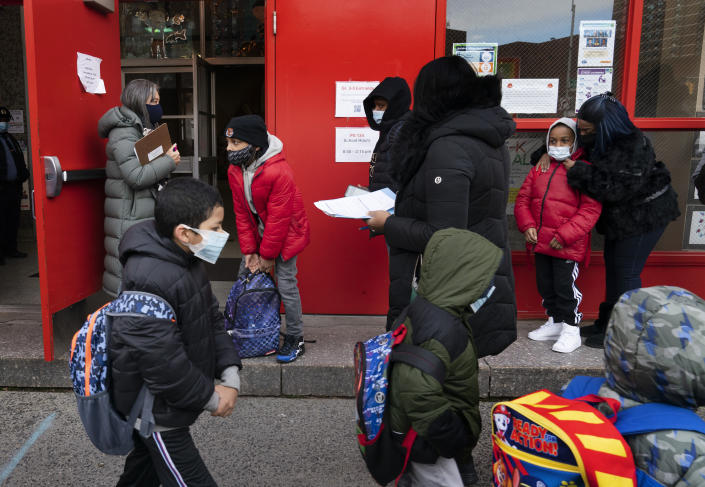 Students enter P.S. 134 Henrietta Szold Elementary School, Monday, Dec. 7, 2020, in New York. Public schools reopened for in-school learning Monday after being closed since mid-November. (AP Photo/Mark Lennihan)