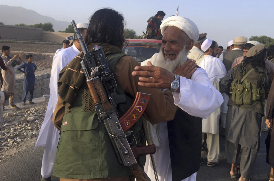 FILE - In this June 16, 2018 file photo, Taliban fighters gather with residents to celebrate a three-day cease fire marking the Islamic holiday of Eid al-Fitr, in Nangarhar province, east of Kabul, Afghanistan. Many Afghans view Saturday's expected signing of a U.S.-Taliban peace deal with a heavy dose of well-earned skepticism. They've spent decades living in a country at war -- some their whole lives — and wonder if they can ever reach a state of peace. (AP Photo/Rahmat Gul, File)