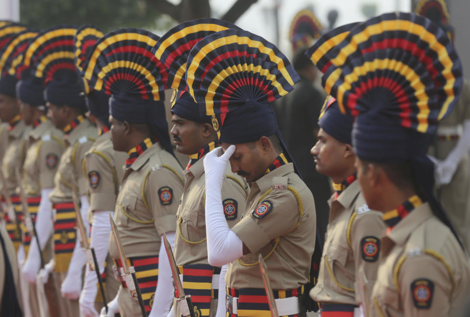 In this Monday, Nov. 26, 2018, file photo, an Indian police officer massages his head as he waits with others to pay tribute to the victims of the Mumbai terror attacks in Mumbai, India. As Mumbai marks the 10th anniversary of attacks that killed 166 in India's financial capital, the United States has made a new reward offer for information on the 2008 siege. (AP Photo/Rafiq Maqbool, File)