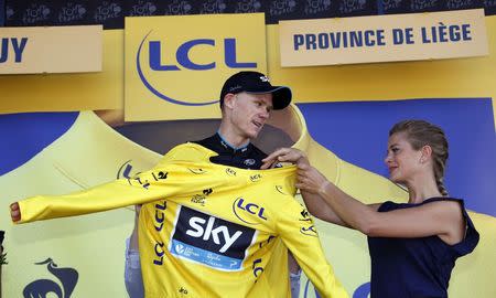 Team Sky rider Chris Froome of Britain celebrates as he wears the race leader's yellow jersey on the podium of the third stage of the 102nd Tour de France cycling race from Anvers to Huy, Belgium, July 6, 2015. REUTERS/Eric Gaillard