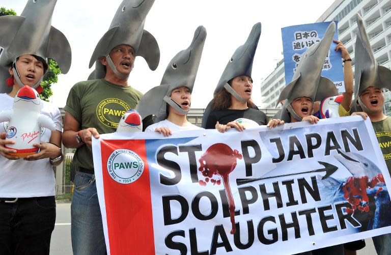 Environmental activists wear dolphin costumes to protest the annual slaughter of dolphins in Taiji, Japan, in front of the Japanese embassy in Manila on October 14, 2010