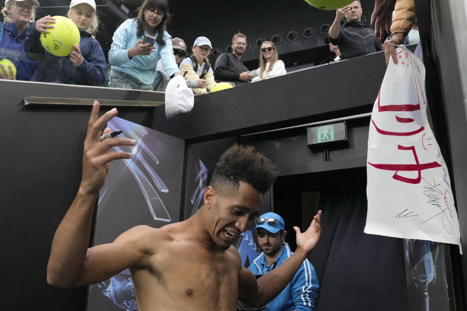 Michael Mmoh of the U.S. signs autographs after defeating Alexander Zverev of Germany in their second round match at the Australian Open tennis championship in Melbourne, Australia, Thursday, Jan. 19, 2023. (AP Photo/Ng Han Guan)