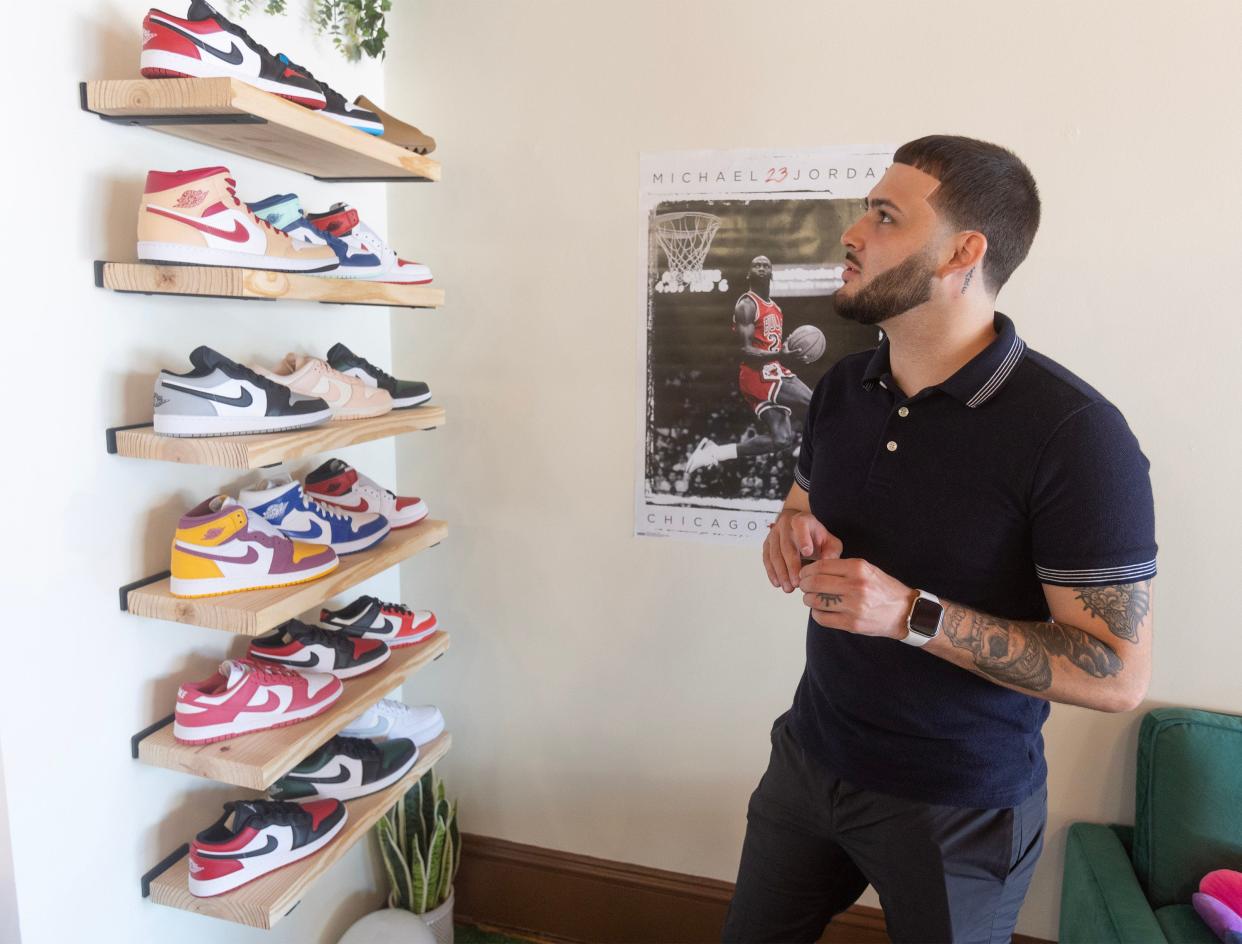 Maverick Sales talks about his shoe display at Golden Tiger Tea shop. Nike and Adidas shoes are for sale at the downtown Massillon business.