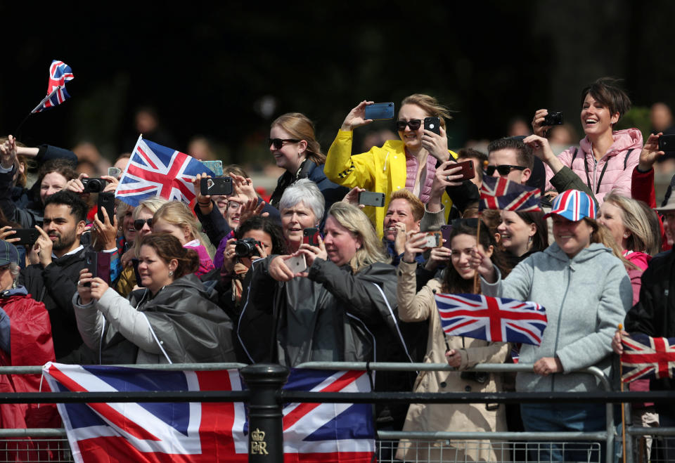 People on their cellphones as they watch the Trooping the Colour parade.