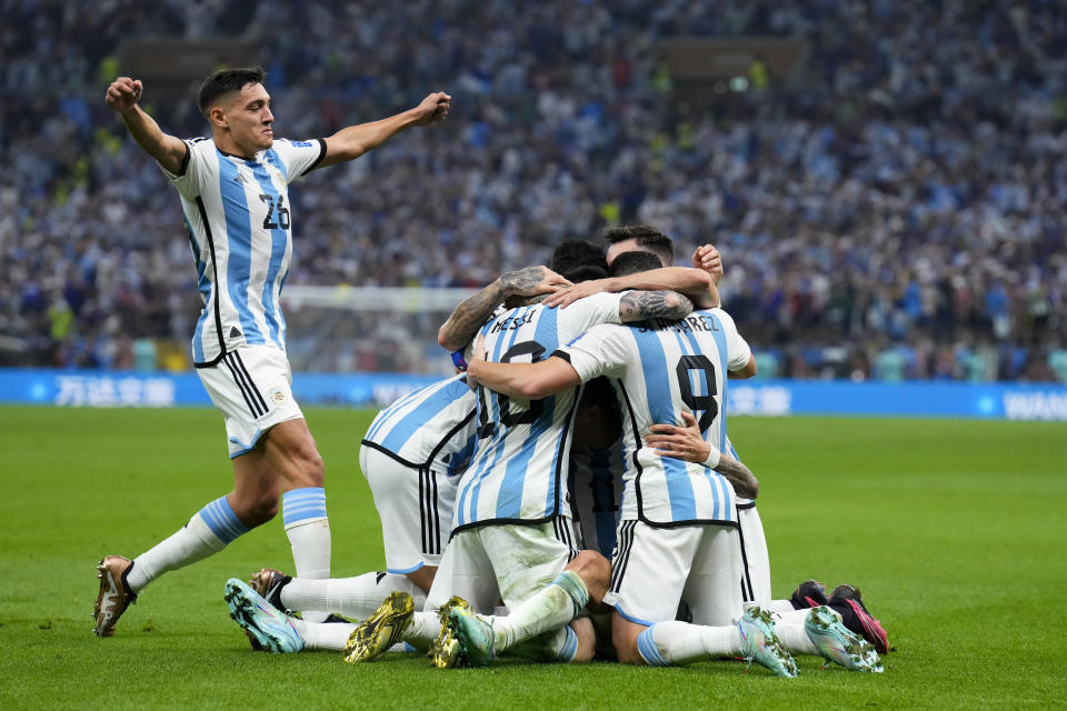 Players of Argentina celebrate with Angel Di Maria after he scored his side's second goal during the World Cup final soccer match between Argentina and France at the Lusail Stadium in Lusail, Qatar, Sunday, Dec. 18, 2022. (AP Photo/Natacha Pisarenko)