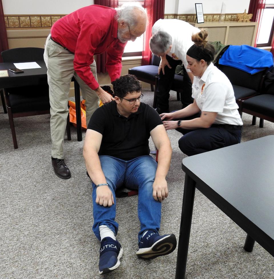 Steve Lavender of Ohio State University and Kayla Chapman of Coshocton County Emergency Medical Services demonstrate use of lift assistance equipment on OSU graduate student Anas Kachlan related to a study and equipment donation on how to better lift patients.