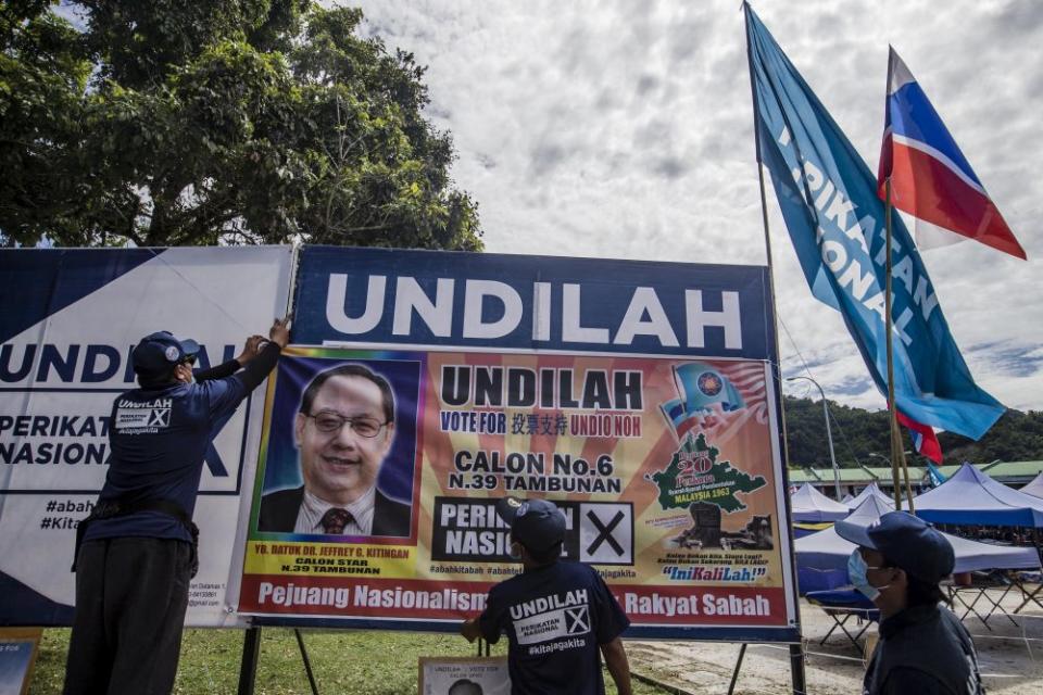 Workers are pictured putting up a poster of STAR president Datuk Jeffrey Kitingan in Tambunan September 24, 2020. — Picture by Firdaus Latif