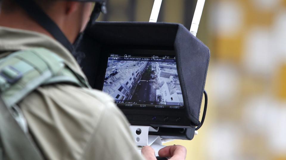 An Israeli soldier uses an unmanned surveillance drone to monitor Palestinian stone throwers in the occupied West Bank city of Hebron as Israeli settlers visit a holy site in 2015. (Hazem Bader/AFP via Getty Images)