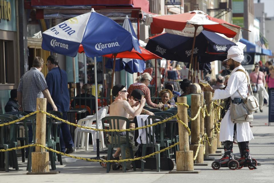 FILE - In this photo taken Feb. 12, 2010, musician Harry Perry, twangs an electric guitar as he rollerblades up and down the Venice Beach boardwalk garbed in a turban and tunic in Los Angeles. Venice Beach, arguably the best free people-watching venue anywhere west of New York's Times Square and with the added bonus that it never gets really cold here. An afternoon stroll down 11Ž2-mile Ocean Front Walk will take people past one of the most colorful collections of skateboarders, street artists, fortune tellers, jugglers, mimes, acrobats, unicycle riders, actors, dancers, musicians, street preachers and armchair philosophers found anywhere in the United States.(AP Photo/Damian Dovarganes, FILE)