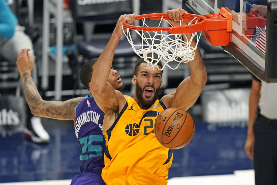 Utah Jazz center Rudy Gobert, right, dunks on Charlotte Hornets forward P.J. Washington (25) in the second half during an NBA basketball game Monday, Feb. 22, 2021, in Salt Lake City. (AP Photo/Rick Bowmer)