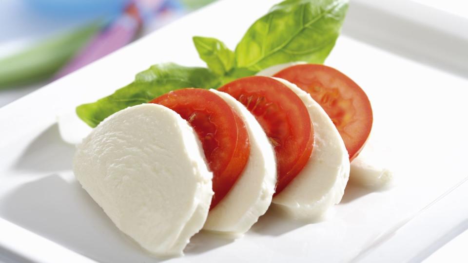 mozzarella cheese with tomatoes and basil, close up