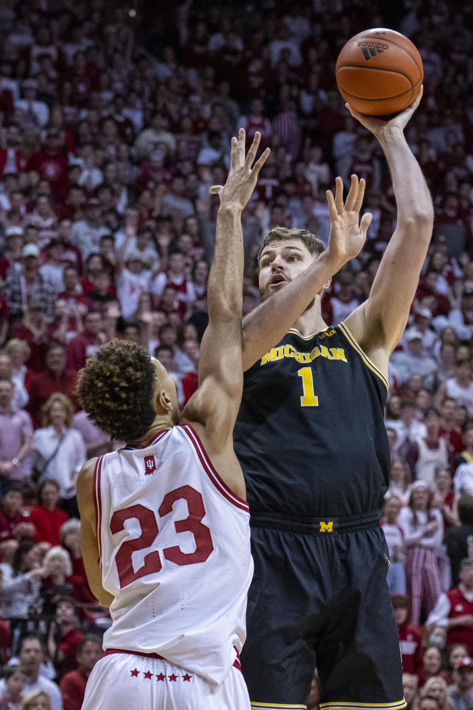 Michigan center Hunter Dickinson (1) shoots while defended by Indiana forward Trayce Jackson-Davis (23) during the first half of an NCAA college basketball game, Sunday, March 5, 2023, in Bloomington, Ind. (AP Photo/Doug McSchooler)