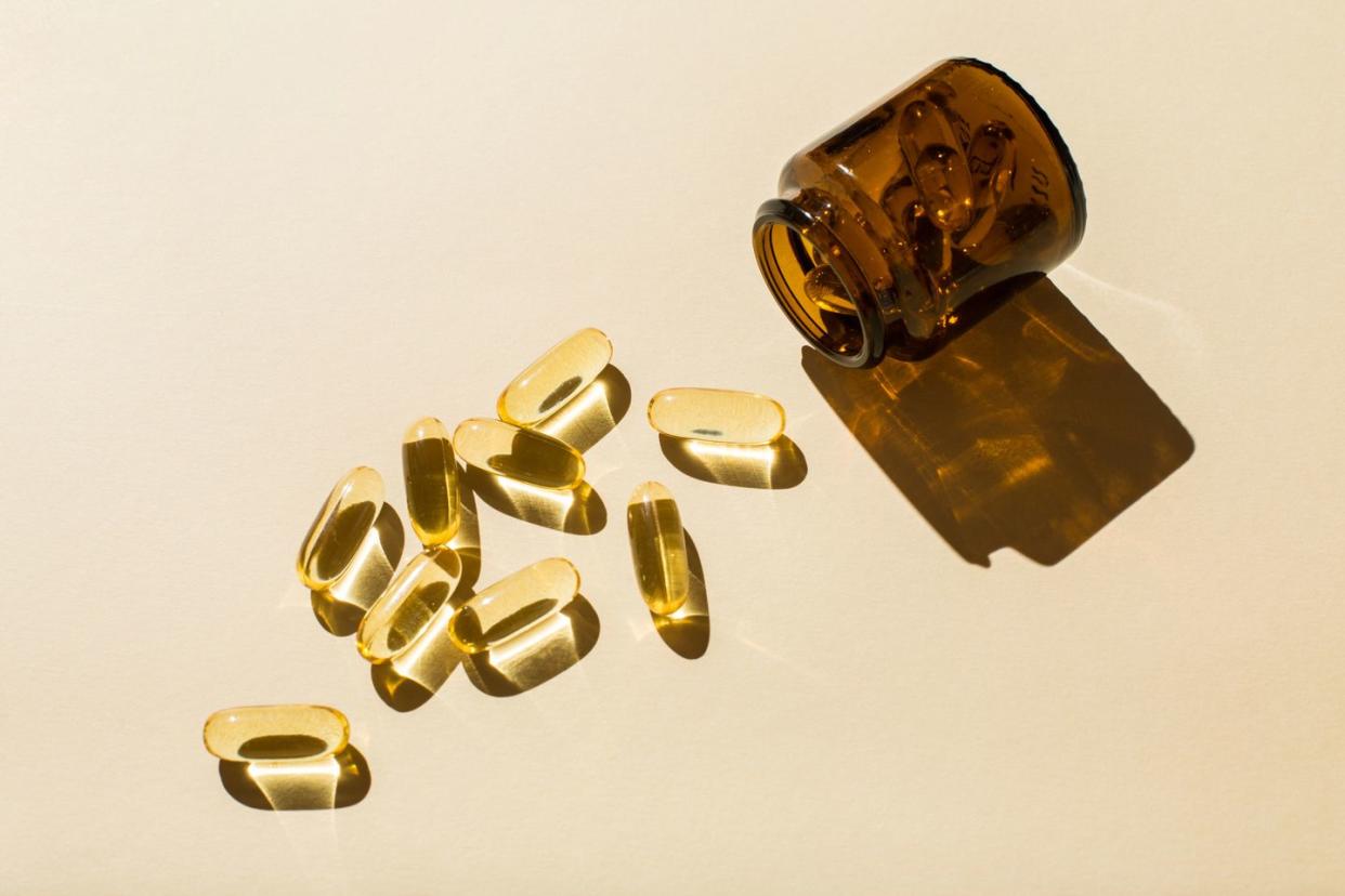 omega 3 fish oil capsules and a glass bottle on a beige background