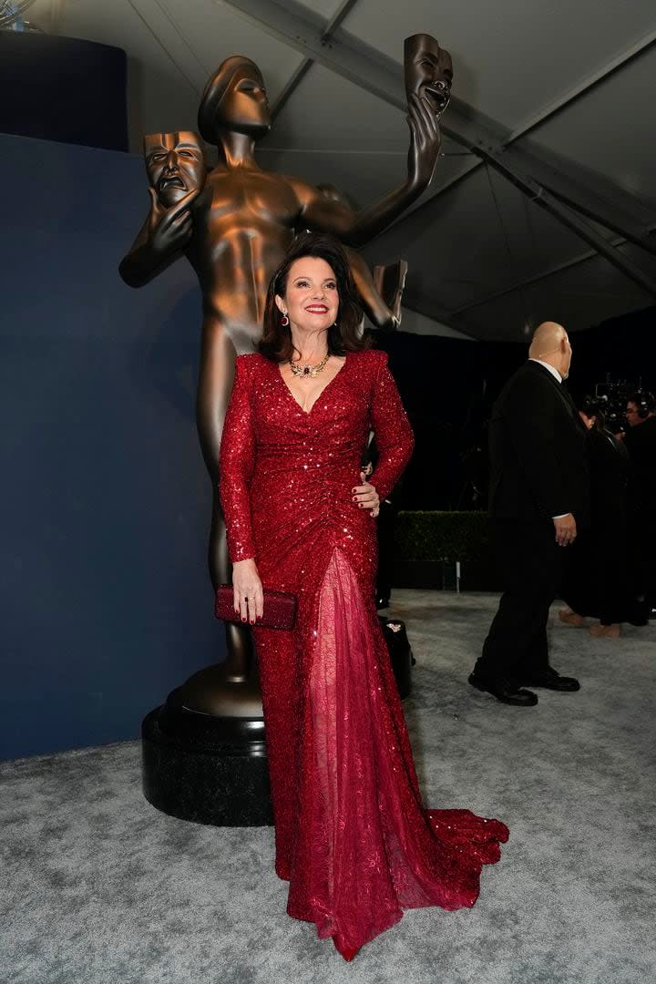 Fran Drescher, la presidenta del sindicato de actores, llegó a la ceremonia de premiación a puro brillo: eligió un vestido largo en rojo con hombreras y mangas largas; acompañó el look con uñas y un clutch a tono