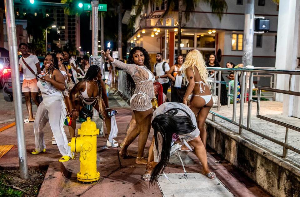 A group of women twerk on Washington Avenue on Saturday, March 26, 2022, an hour before a midnight curfew imposed by the City of Miami Beach for the South Beach area, because of to two shootings in Miami Beach the weekend before, that caused city officials to announce a “state of emergency”.