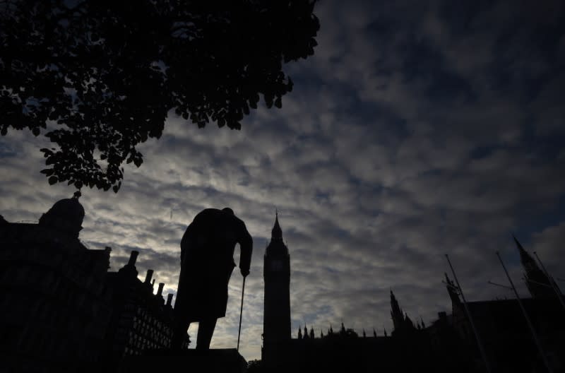 Dawn breaks behind the Houses of Parliament and the statue of Winston Churchill in Westminster, London, Britain June 24, 2016. REUTERS/Toby Melville