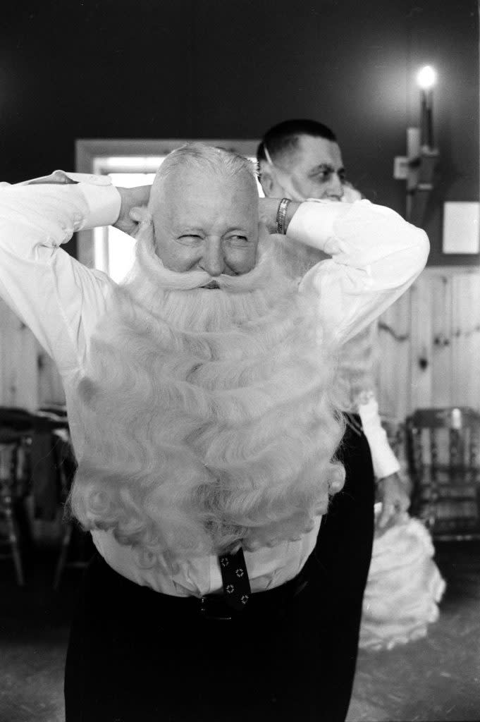 Charles Howard displaying how to properly wear Santa's beard for a small class at Santa school. (Alfred Eisenstaedt/The LIFE Picture Collection via Shutterstock)) 