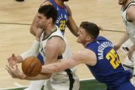 Denver Nuggets' Isaiah Hartenstein and Milwaukee Bucks' Brook Lopez go after a loose ball during the first half of an NBA basketball game Tuesday, March 2, 2021, in Milwaukee. (AP Photo/Morry Gash)