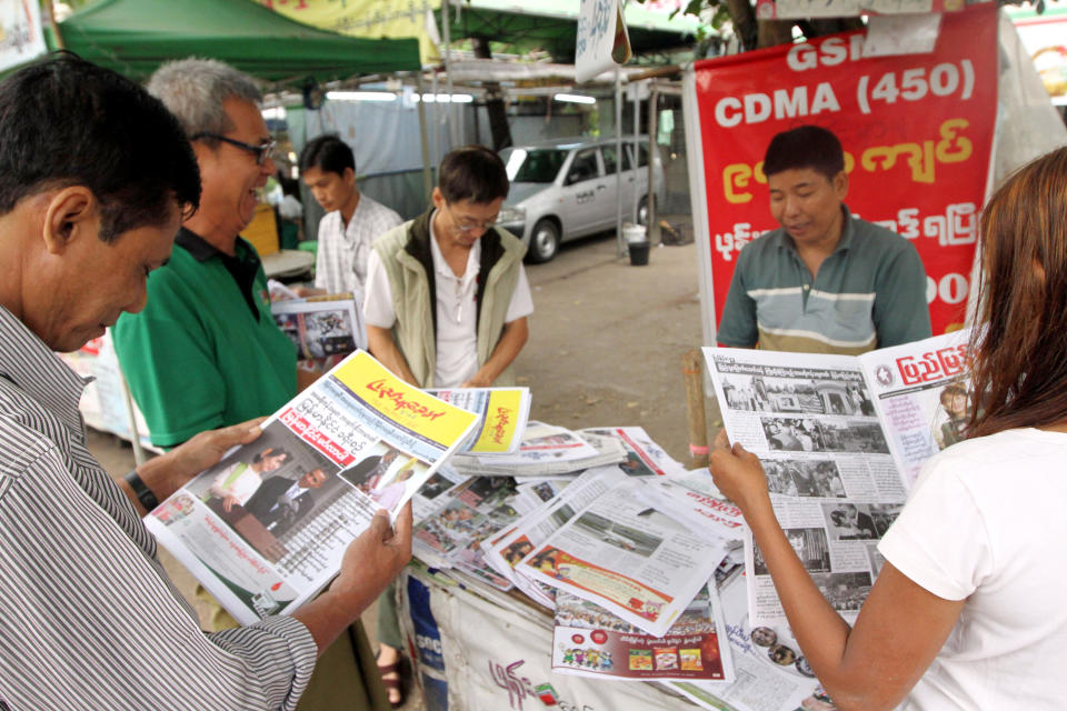 In this Nov. 20, 2012, photo, people browse local weekly news journals reporting U.S. President Barack Obama's trip to Myanmar at a newsstand, in Yangon, Myanmar. Little noticed during Obama's landmark visit to Myanmar was a significant concession that could shed light on whether that nation's powerful military pursued a clandestine nuclear weapons program, possibly with North Korea's help. Myanmar announced it would sign an international agreement that would require it to declare all nuclear facilities and materials. Although it would be up to Myanmar to decide what to declare, it could provide some answers concerning its acquisition of dual-use machinery and military cooperation with North Korea. (AP Photo/Khin Maung Win)