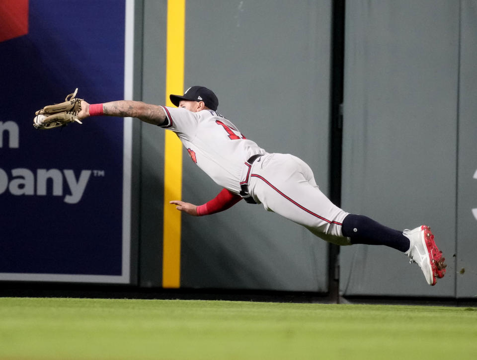 Atlanta Braves left fielder Kevin Pillar catches a fly ball off the bat of Colorado Rockies' Nolan Jones in the sixth inning of a baseball game Monday, Aug. 28, 2023, in Denver. (AP Photo/David Zalubowski)