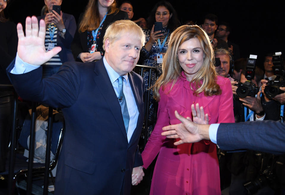 Britain's Prime Minister Boris Johnson leaves the stage after he finishes his Leader's speech and joins his girlfriend Carrie Symonds, during the Conservative Party Conference in Manchester, England, Wednesday, Oct. 2, 2019. (Jeremy Selwyn/Pool via AP)