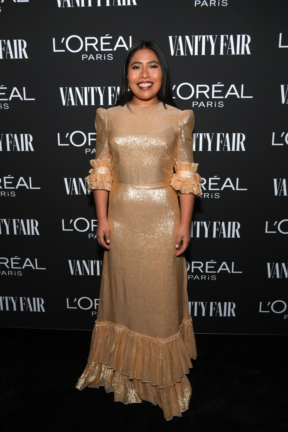 En la fiesta de Vanity Fair, previo a la ceremonia de los Oscares, lució un elegante vestido dorado con mangas a tres cuartos y holanes. / Foto: Emma McIntyre/Getty Images for Vanity Fair