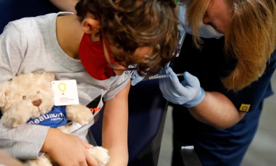 A seven-year-old receives their first dose of the Pfizer Covid-19 vaccine at the Beaumont Health offices in Southfield, Michigan.