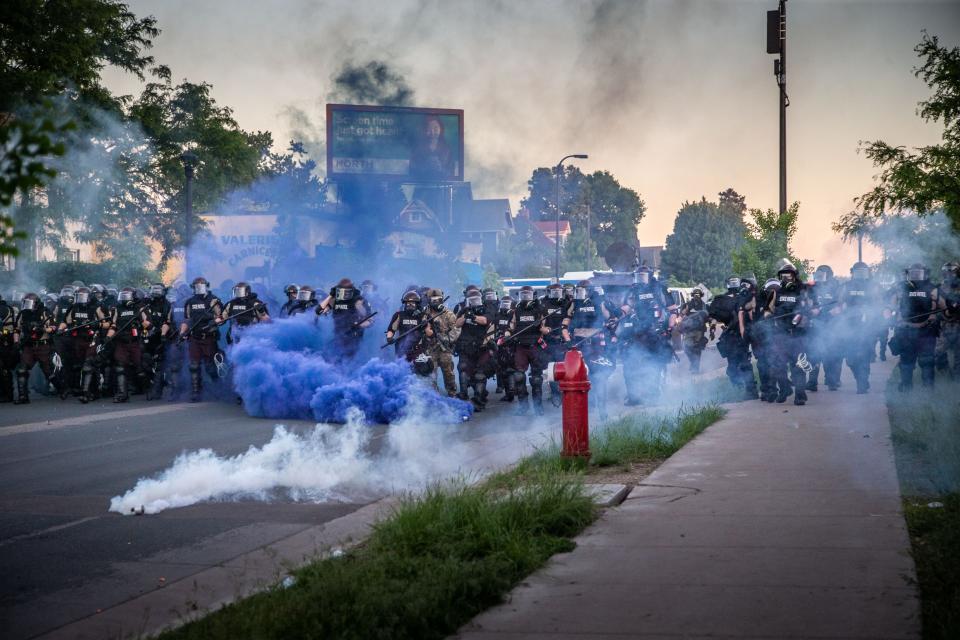 Minnesota state troopers fire smoke and tear gas as they advance on protesters outside the Fifth Police Precinct in Minneapolis on Saturday, May 30, 2020.