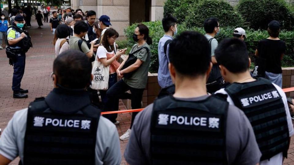 People queue up outside the West Kowloon Magistrates' Courts building, before the verdict of the 47 pro-democracy activists