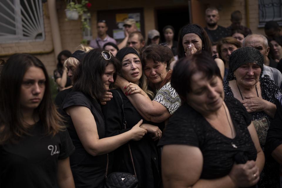 Anastasia Ohrimenko, 26, is comforted by relatives and friends as she cries next to a coffin with the body of her husband Yury Styglyuk, a Ukrainian serviceman who died in combat on Aug. 24 in Maryinka, Donetsk, during his funeral in Bucha, Ukraine, Aug. 31, 2022. The image was part of a series of images by Associated Press photographers that was awarded the 2023 Pulitzer Prize for Breaking News Photography. (AP Photo/Emilio Morenatti)
