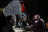 Turks and tourists visit a mosque compound in Istanbul, Wednesday, Aug. 15, 2018. The Turkish lira has nosedived in value in the past week over concerns about Turkey's President Recep Tayyip Erdogan's economic policies and after the United States slapped sanctions on Turkey angered by the continued detention of an American pastor. (AP Photo/Lefteris Pitarakis)