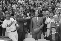 FILE - In this April 7, 1969, file photo, President Richard Nixon and Baseball Commissioner Bowie Kuhn, center-left, join Washington Senators manager Ted Williams, left, in a round of laughter before the chief executive tossed out the first ball in an opening day baseball game at RFK Stadium in Washington. (AP Photo/File)
