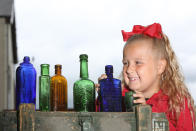 A seven-year-old schoolgirl is raking in hundreds of pounds by selling antique bottles from a little shop in her back garden - after digging them up from old landfill sites. Betsy-Mae Lloyd has been coining it in after launching her own business at her parents' home while still attending primary school. The young entrepreneur flogs old bottles, jars and teapots - dating back to between the 1870s and 1930 - which she finds on historic landfill sites in the West Midlands. After taking them home and cleaning them up herself, she then stores them in a Victorian-style play shed, built by dad Jason, before listing them for sale on Facebook. 