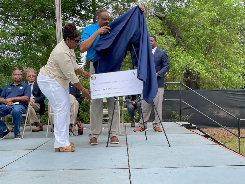Midway City Council Member NanDrycka King Albert, left, helps Congressman Al Lawson unveil a check for $2 million to expand a recreation center.