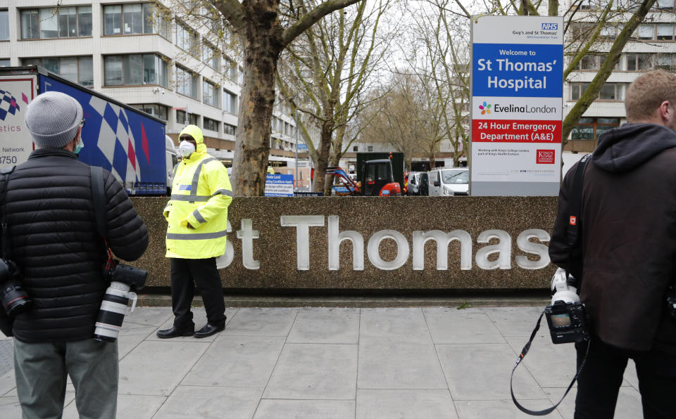 Media wait outside a hospital where it is believed that Britain's Prime Minister Boris Johnson is undergoing tests after suffering from coronavirus symptoms, in London, Monday, April 6, 2020. British Prime Minister Boris Johnson has been admitted to a hospital with the coronavirus. Johnson's office says he is being admitted for tests because he still has symptoms 10 days after testing positive for the virus. (AP Photo/Frank Augstein)