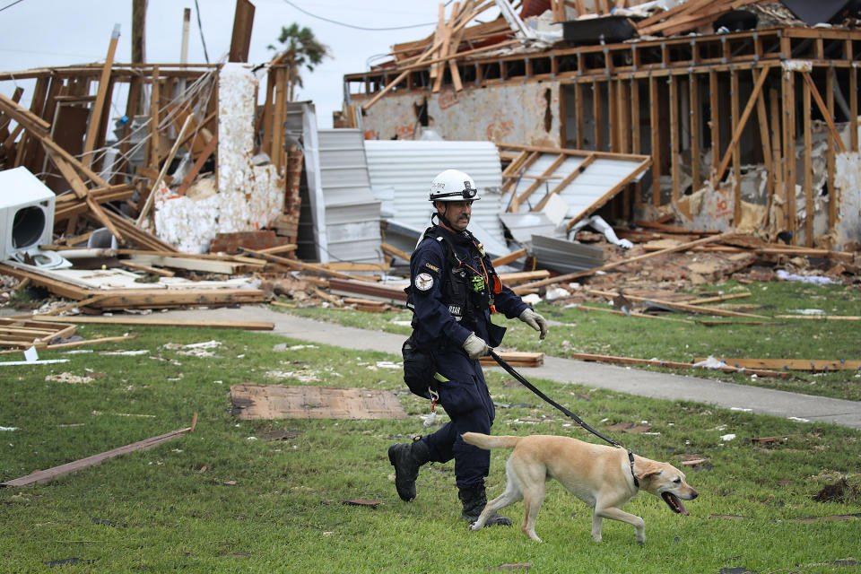 <p>Robert Grant and Rocky from the Texas Task Force 2 search and rescue team work through a destroyed apartment complex trying to find anyone that still may be in the apartment complex after Hurricane Harvey passed through on Aug. 27, 2017 in Rockport, Texas. (Photo: Joe Raedle/Getty Images) </p>