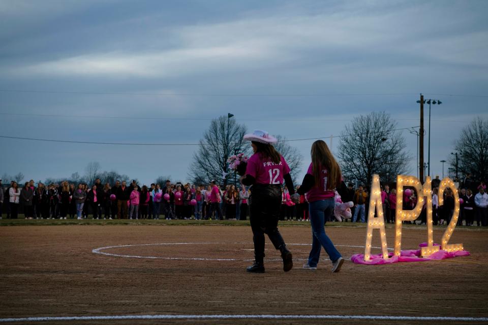 Randi Jo Pryor, left, and Peyton Pryor take the field for their sister, Ashton Pryor's candlelight celebration at Mike Wilson Field at Boonville High School in Boonville, Ind., Sunday evening, Feb. 19, 2023. Ashton was killed Friday morning in a single car accident while on her way to school.