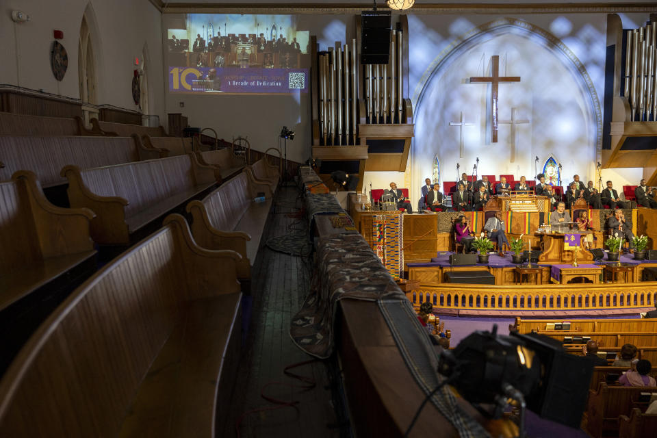 A second floor set of pews sits empty as a projection of a sermon is displayed on a wall during Palm Sunday services at the Metropolitan AME Church in Washington, Sunday, March 24, 2024. Rev. William Lamar IV at Washington, D.C.’s historic Metropolitan AME has adjusted to offering both virtual and in-person services since the COVID-19 pandemic. After a noticeable attendance drop, more Metropolitan congregants are choosing in-person worship over virtual, even as they mourn members who died from COVID-19. (AP Photo/Amanda Andrade-Rhoades)