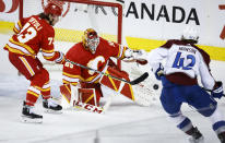 Colorado Avalanche defenceman Josh Manson (42) has his shot kicked away by Calgary Flames goalie Jacob Markstrom, centre, as Flames right wing Tyler Toffoli (73) looks on during the third period of an NHL hockey game Tuesday, March 29, 2022 in Calgary, Alberta. (Jeff McIntosh/The Canadian Press via AP)