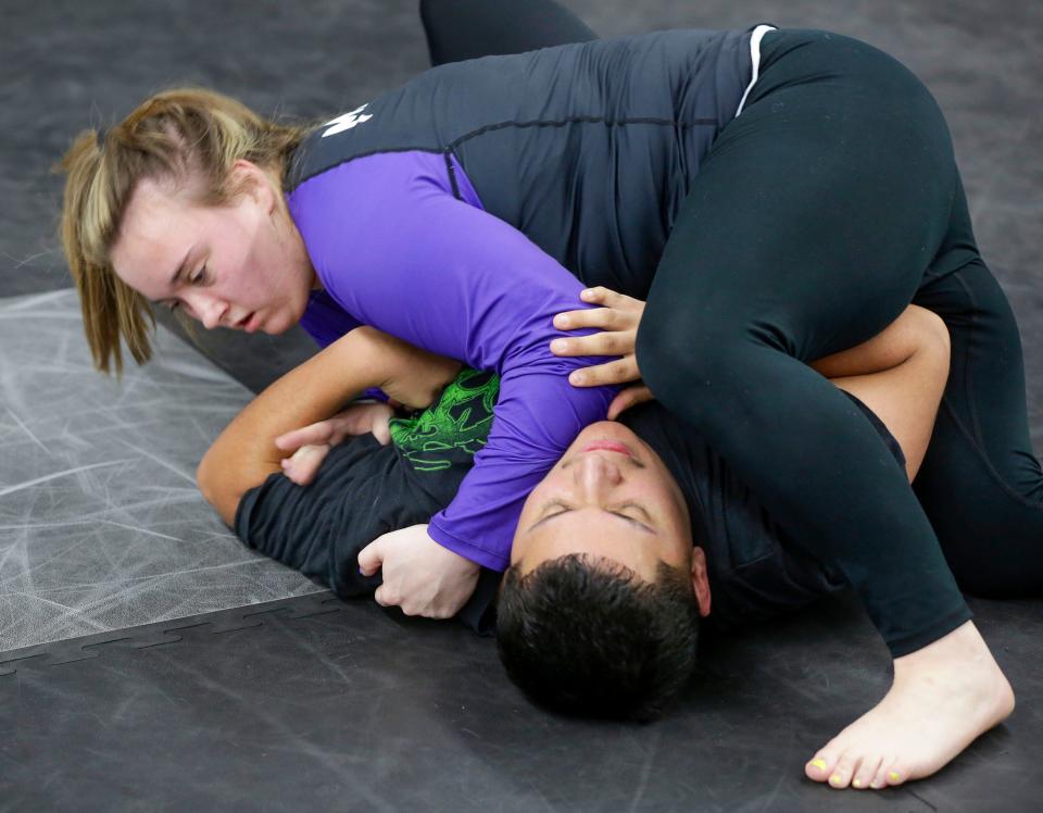 Maggie Wickenhauser, top, works to contain Elian Solis, both of Sheboygan, during a Jiu Jitsu class, Monday, November 13, 2023, in Sheboygan, Wis.