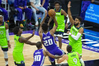 The Minnesota Timberwolves center Karl-Anthony Towns (32) defends the basket as Sacramento Kings center Hassan Whiteside (20) shoots during the first quarter of an NBA basketball game in Sacramento, Calif., Tuesday, April 20, 2021. (AP Photo/Randall Benton)